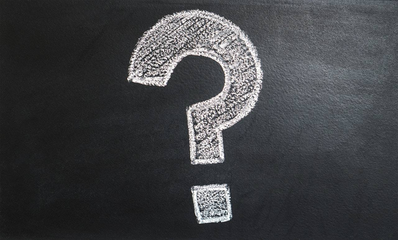 Photograph of a question mark drawn in chalk on a black board