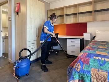 Housekeeping staff cleaning a student room